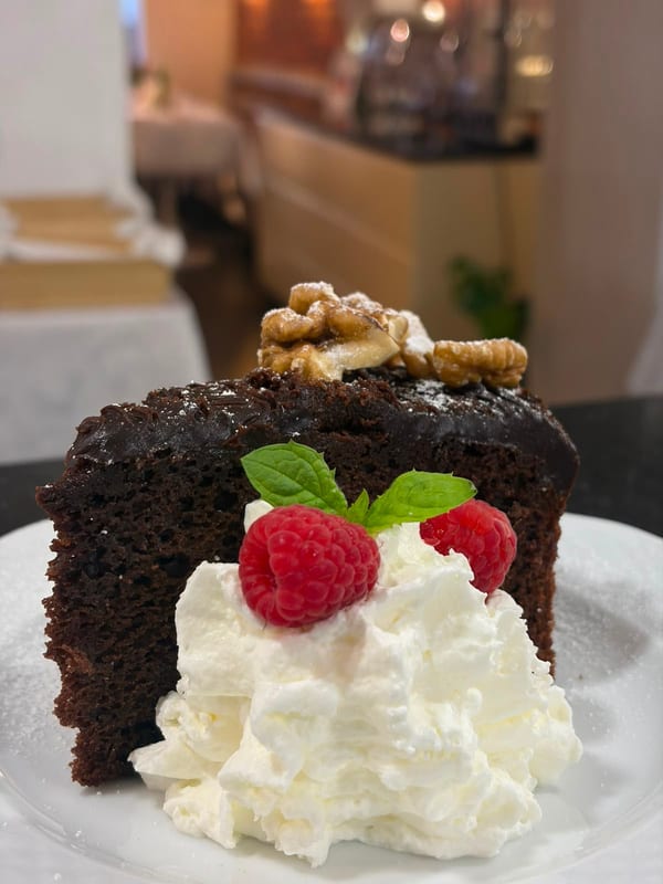 Restauracja Celestin's chocolate cake with whipped cream, raspberries and walnuts