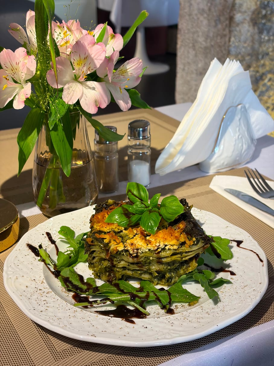 A layered spinach stack with basil and rocket, laid on Restauracja Celestin's table