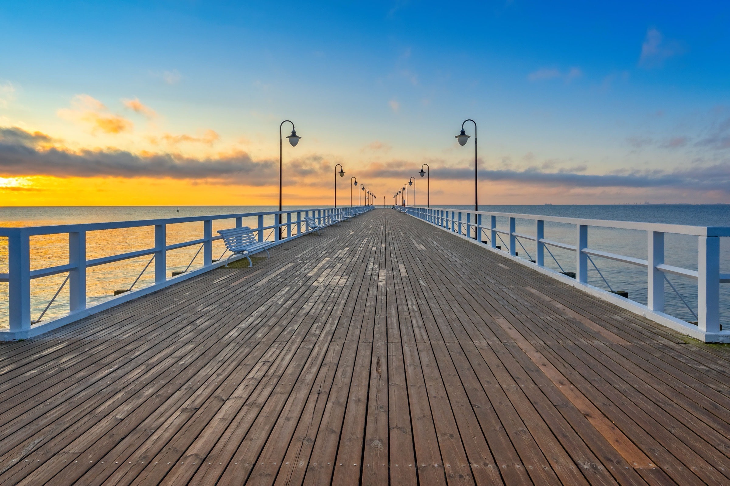 First light on the empty wooden pier at Gdynia Orłowo, the Baltic calm to the horizon