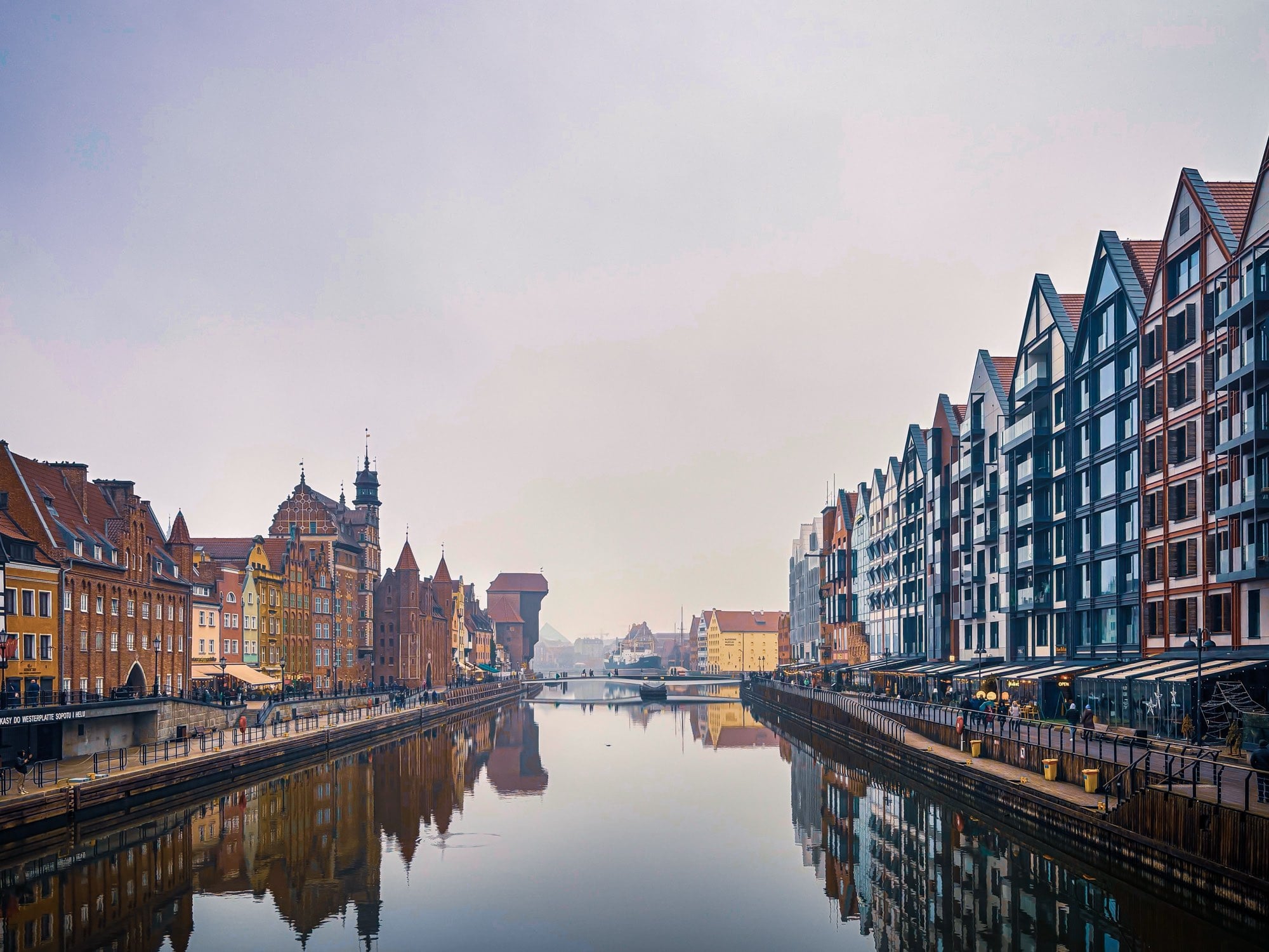 The Motława seen from a Gdańsk bridge — the Old Town waterfront, granary gables and the Crane doubled in the still water
